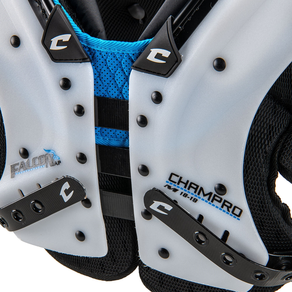 Close-up of white football shoulder pads with black and blue accents, featuring the Champro brand.