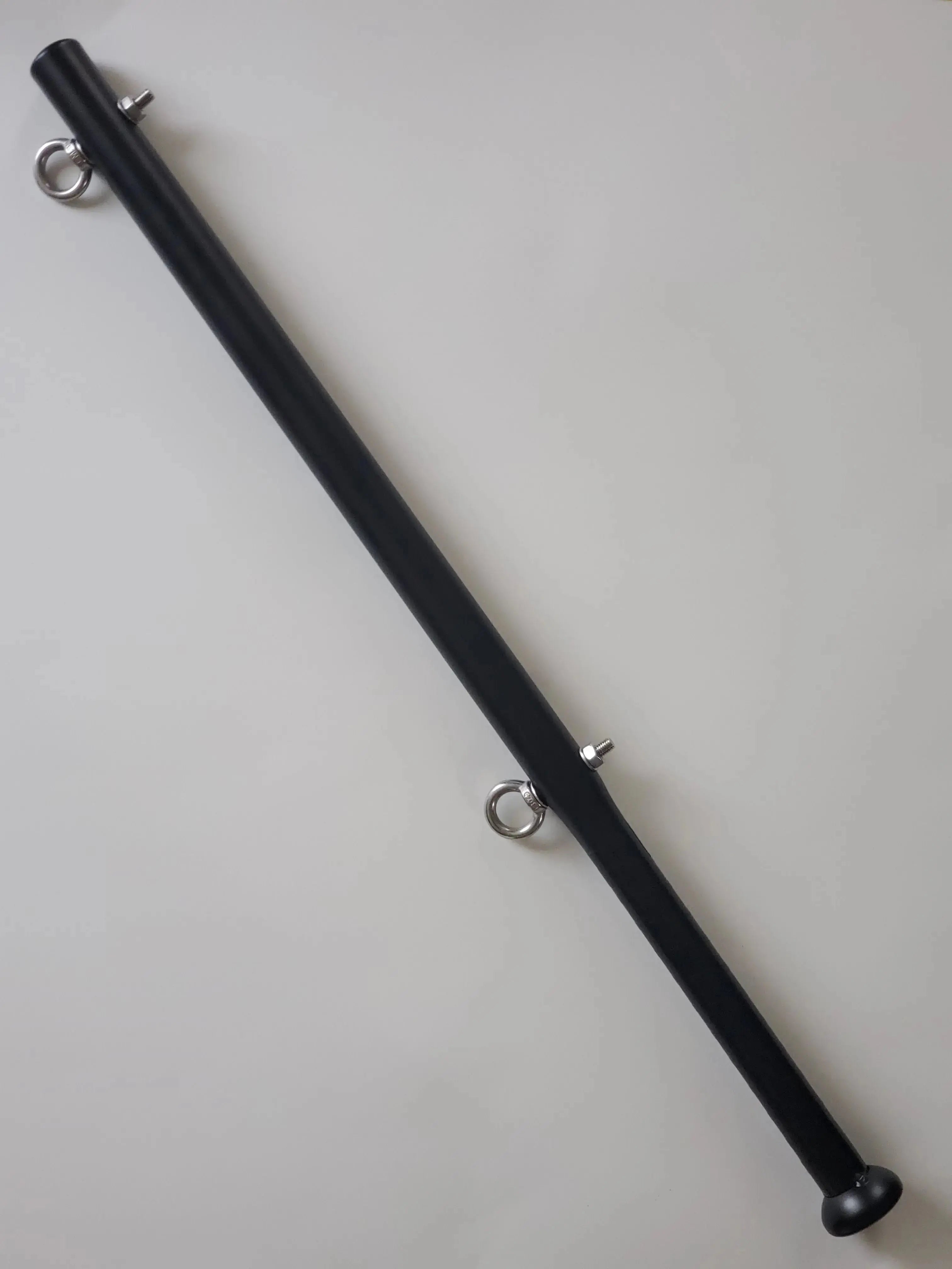 Black metal rod with circular ends on a white background