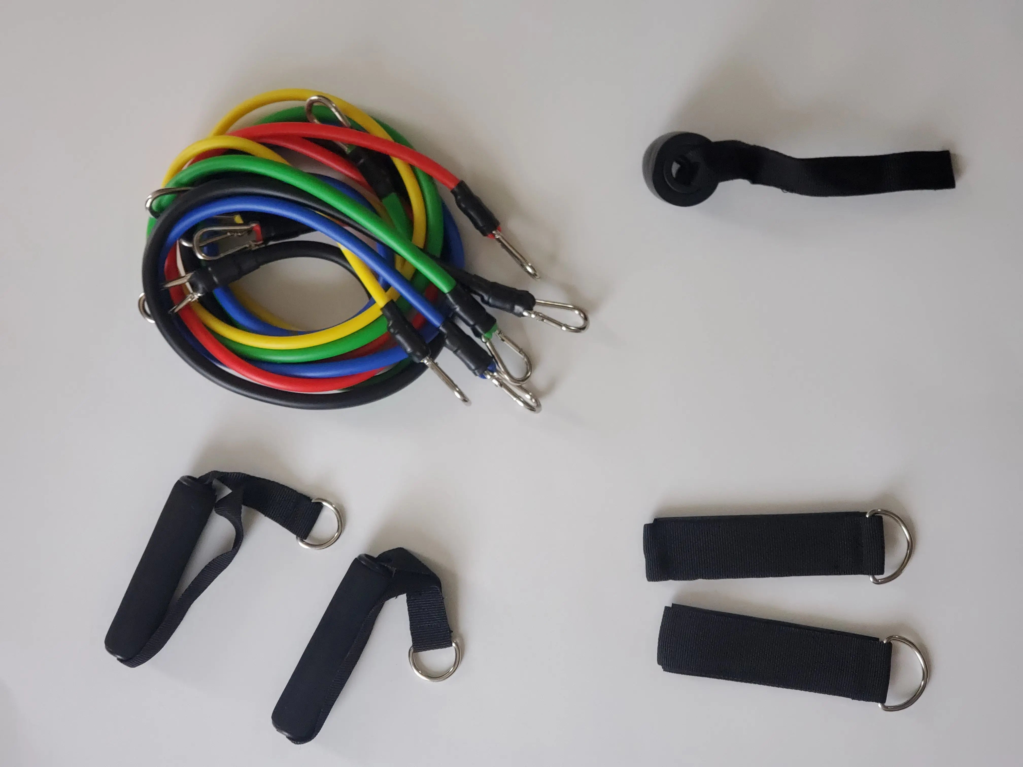 Set of colorful resistance bands and black straps on a white background