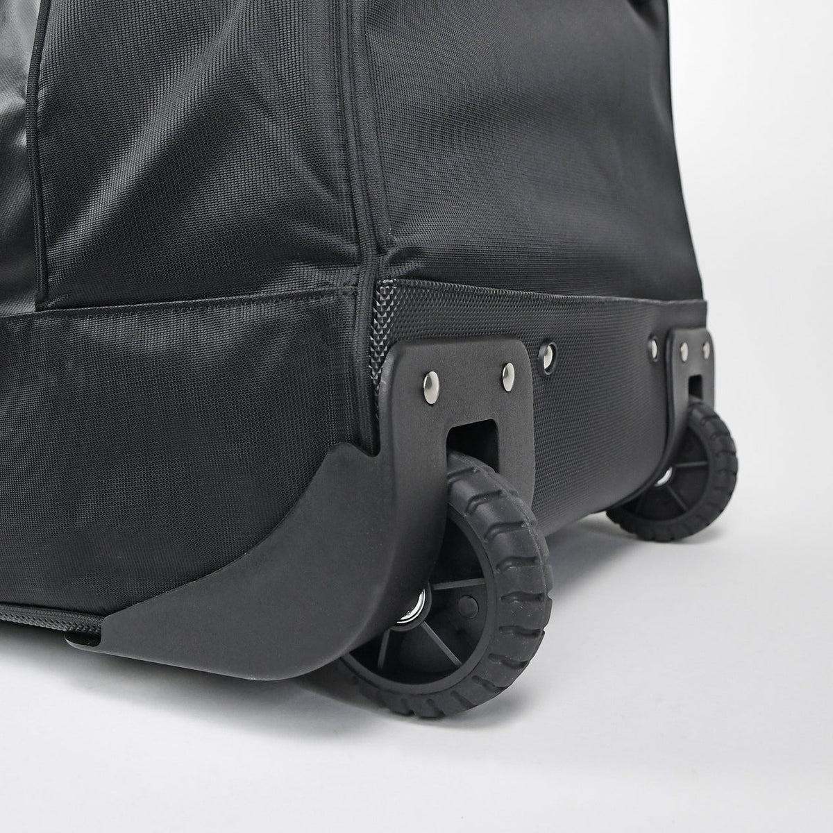 Close-up of a black suitcase with wheels on a light gray background