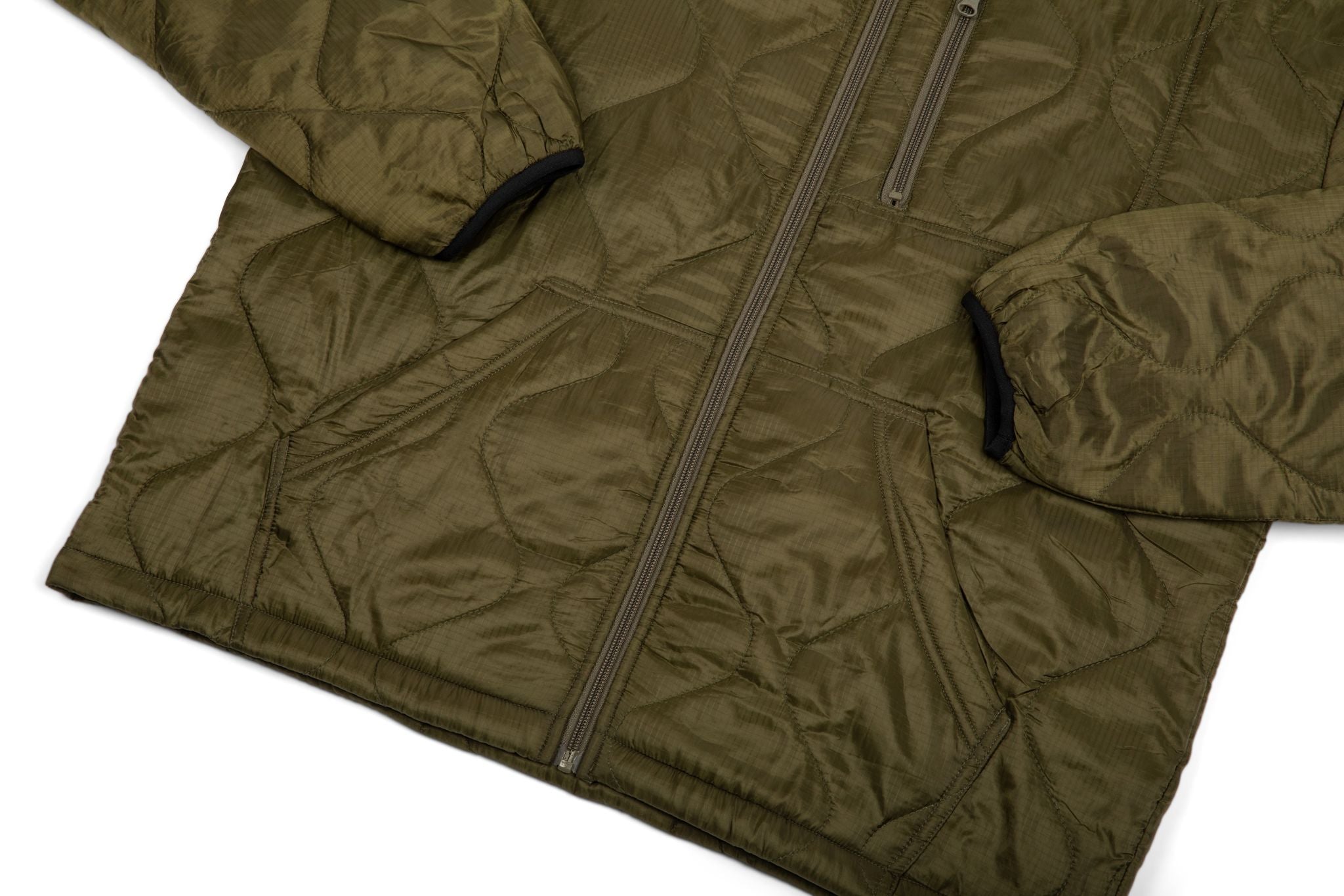 Green quilted jacket with a zipper on a white background