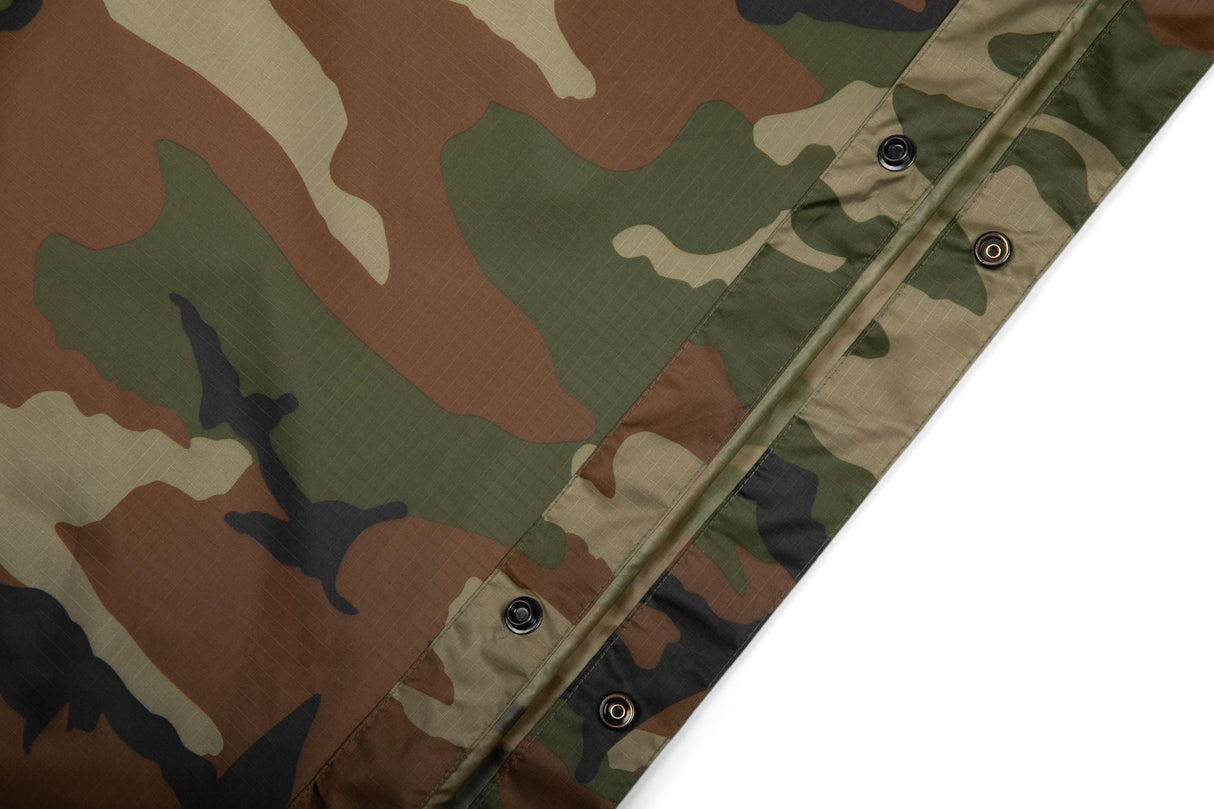 Camouflage-patterned fabric with button details on a white background