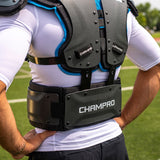 Person wearing a black protective vest with 'Champro' branding on a sports field. 