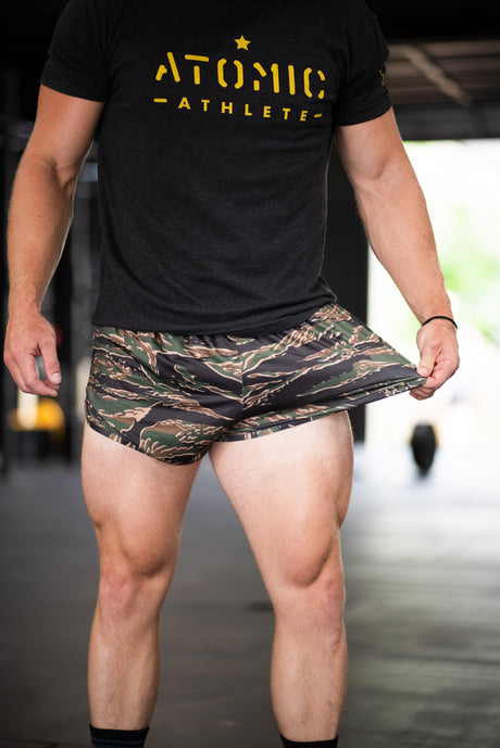 Person wearing a black 'Atomic Athlete' t-shirt and camouflage shorts.