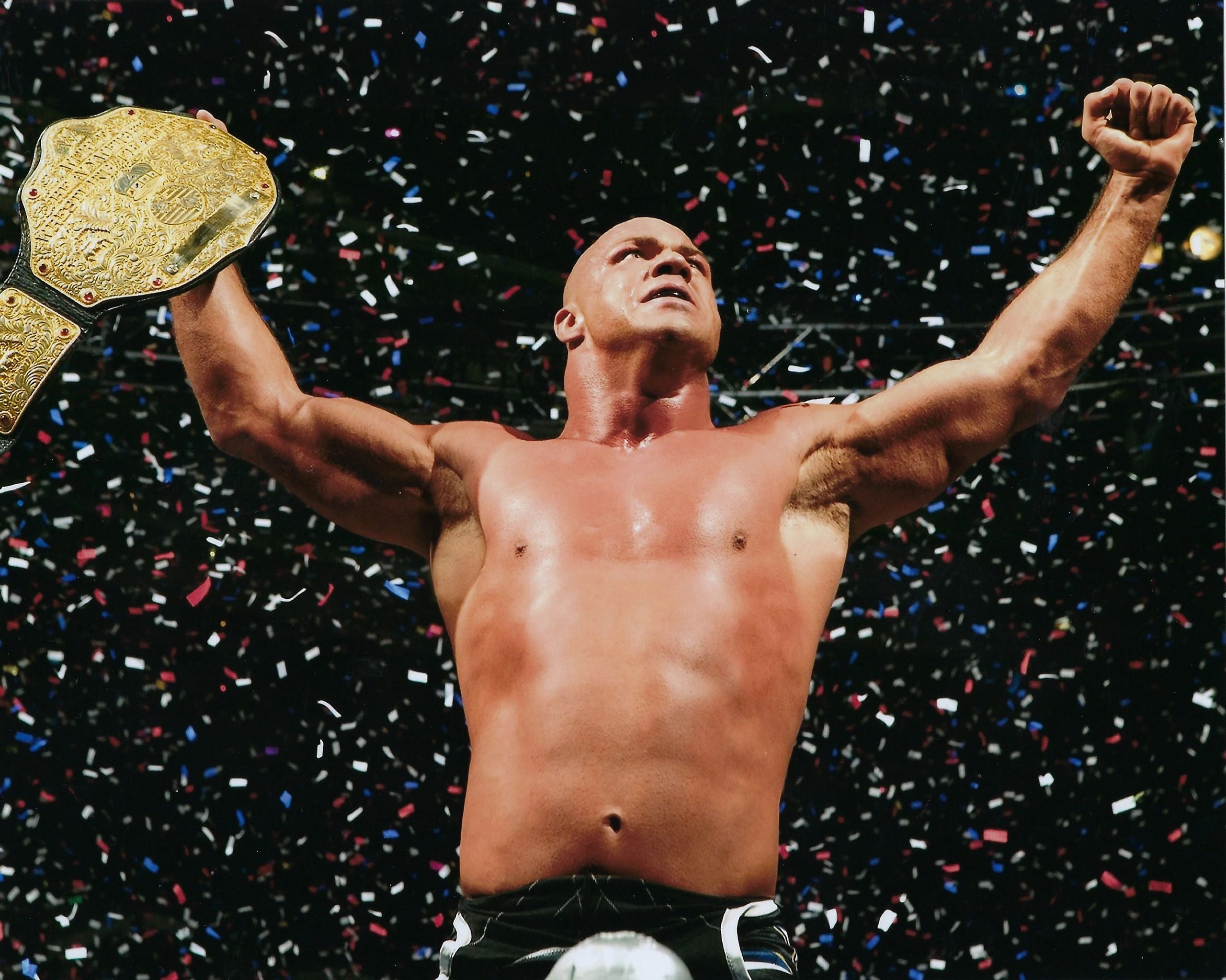 Kurt Angle Signed 8x10 Photo Championship Belt Held over his head with Confetti W/JSA COA