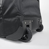Close-up of a black suitcase with wheels on a light gray background