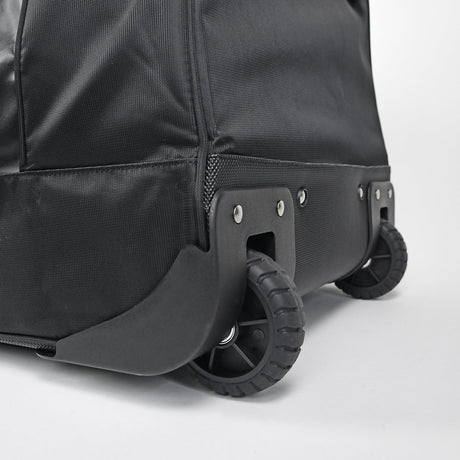 Close-up of a black suitcase with wheels on a light gray background
