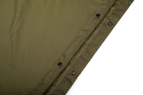Close-up of a green fabric with button details on a white background