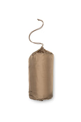 Tan compression sack with a rope handle on a white background
