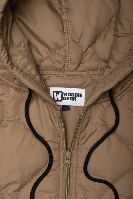 Close-up of a brown quilted jacket with a visible brand label on the hood.