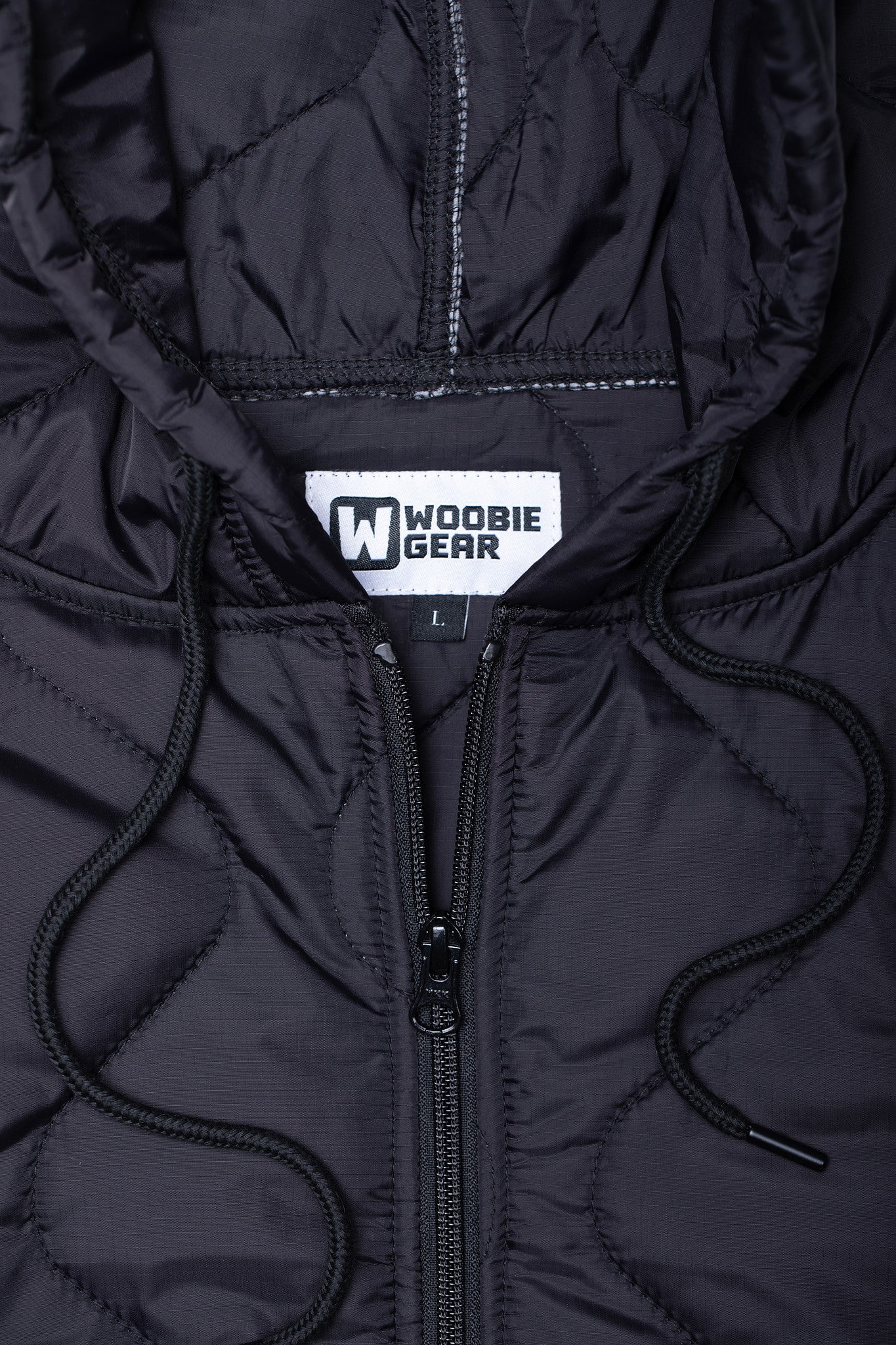 Close-up of a black jacket with a visible brand label on the chest.